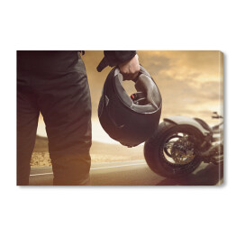 Obraz na płótnie Motocyklista stojący z kaskiem na drodze