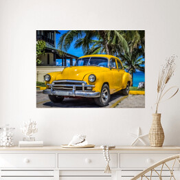 Plakat samoprzylepny Żółty amerykański klasyczny samochód zaparkowany pod palmami na plaży w Varadero na Kubie 