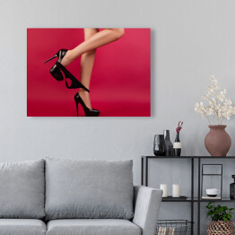 Obraz na płótnie Seksowne kobiece nogi w szpilkach na czerwonym tle 