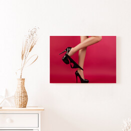 Obraz na płótnie Seksowne kobiece nogi w szpilkach na czerwonym tle 