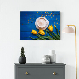 Obraz na płótnie Kubek kawy z żółtymi tulipanami i notatka na błękitnym stole