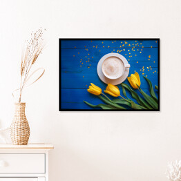 Plakat w ramie Kubek kawy z żółtymi tulipanami i notatka na błękitnym stole