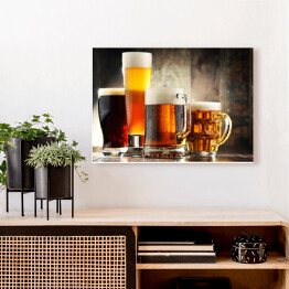 Obraz na płótnie Cztery kufle z piwem na drewnianym tle