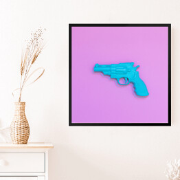 Obraz w ramie Niebieski pistolet na różowym tle