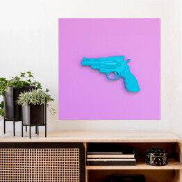 Plakat samoprzylepny Niebieski pistolet na różowym tle