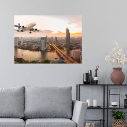Plakat samoprzylepny Samolot na tle panoramy miasta o zachodzie słońca