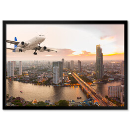 Plakat w ramie Samolot na tle panoramy miasta o zachodzie słońca