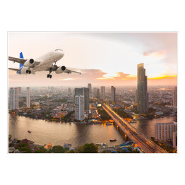 Plakat Samolot na tle panoramy miasta o zachodzie słońca