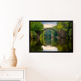 Obraz w ramie Odbijający się most w tafli rzeki w Parku Kromlau w Niemczech
