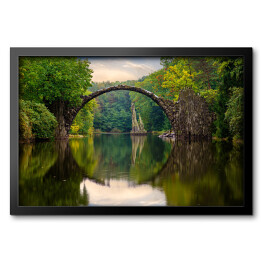 Obraz w ramie Odbijający się most w tafli rzeki w Parku Kromlau w Niemczech