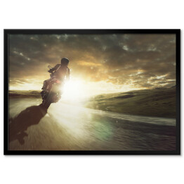 Plakat w ramie Motocykl jadący na zakręcie o zachodzie słońca