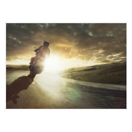 Plakat samoprzylepny Motocykl jadący na zakręcie o zachodzie słońca
