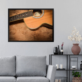 Obraz w ramie Gitara akustyczna na tle imiującym nieociosane drewno