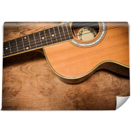 Gitara akustyczna na tle imiującym nieociosane drewno