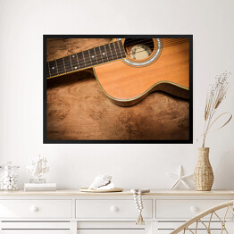 Obraz w ramie Gitara akustyczna na tle imiującym nieociosane drewno