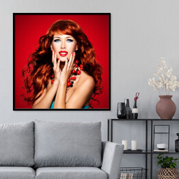 Plakat w ramie Piękna zmysłowa kobieta z długimi czerwonymi włosami na czerwonym tle