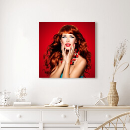 Obraz na płótnie Piękna zmysłowa kobieta z długimi czerwonymi włosami na czerwonym tle