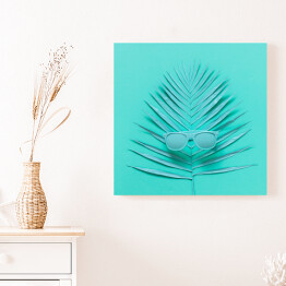 Obraz na płótnie Okulary przeciwsłoneczne leżące na liściu palmy - niebieska ilustracja