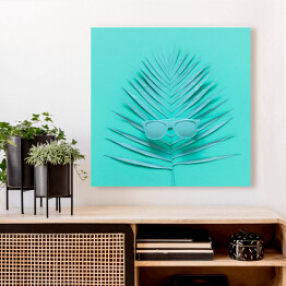 Obraz na płótnie Okulary przeciwsłoneczne leżące na liściu palmy - niebieska ilustracja
