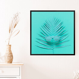Obraz w ramie Okulary przeciwsłoneczne leżące na liściu palmy - niebieska ilustracja