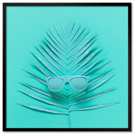Plakat w ramie Okulary przeciwsłoneczne leżące na liściu palmy - niebieska ilustracja