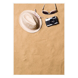 Plakat samoprzylepny Okulary przeciwsłoneczne, wiklinowy kapelusz i aparat fotograficzny na piasku