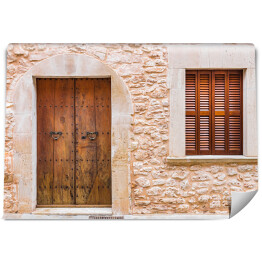 Fototapeta Rustykalne drewniane drzwi do domu i ściany z kamienia