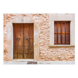 Rustykalne drewniane drzwi do domu i ściany z kamienia