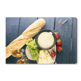 Obraz na płótnie Szwajcarska fondue z bukietem serów na desce i truskawkami 