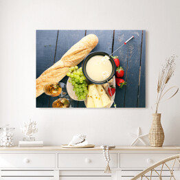 Obraz na płótnie Szwajcarska fondue z bukietem serów na desce i truskawkami 