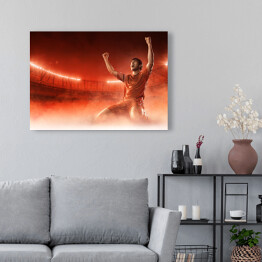 Obraz na płótnie Piłkarz świętuje bramkę na przydymionym czerwonym tle 