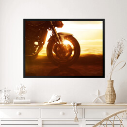 Obraz w ramie Koło motocyklu na tle złocistego zachodu słońca