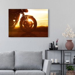 Obraz na płótnie Koło motocyklu na tle złocistego zachodu słońca