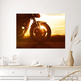 Plakat samoprzylepny Koło motocyklu na tle złocistego zachodu słońca