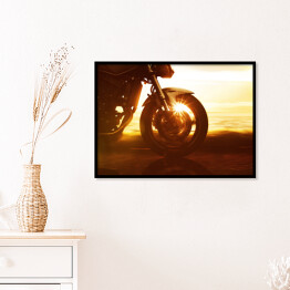 Plakat w ramie Koło motocyklu na tle złocistego zachodu słońca