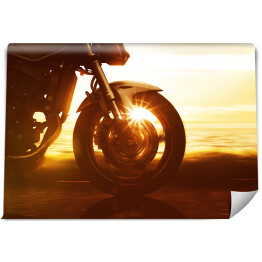 Fototapeta Koło motocyklu na tle złocistego zachodu słońca