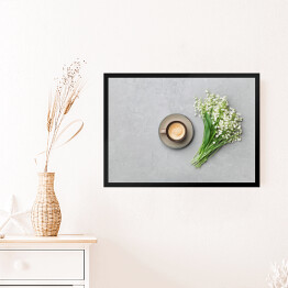Obraz w ramie Kubek kawy z bukietem konwalii na szarym stole z kamienia 