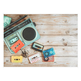 Plakat Widok z góry - radio i kasety z wyciągniętą taśmą na drewnianym stole