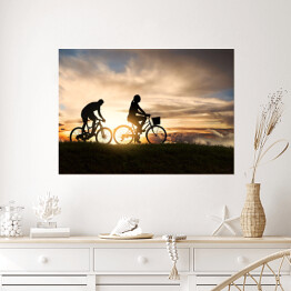 Młoda para jadąca rowerami o zachodzie słońca