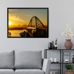 Obraz w ramie Most nad rzeką w mieście ze spektakularnym wschodem słońca w tle