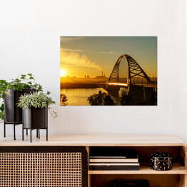 Plakat samoprzylepny Most nad rzeką w mieście ze spektakularnym wschodem słońca w tle