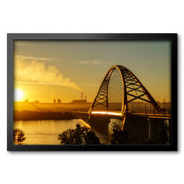 Obraz w ramie Most nad rzeką w mieście ze spektakularnym wschodem słońca w tle