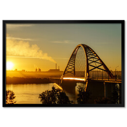 Plakat w ramie Most nad rzeką w mieście ze spektakularnym wschodem słońca w tle