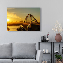 Obraz na płótnie Most nad rzeką w mieście ze spektakularnym wschodem słońca w tle