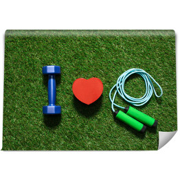 Kolorowe hantle z symbolem serca i skakanką na trawie