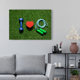 Kolorowe hantle z symbolem serca i skakanką na trawie