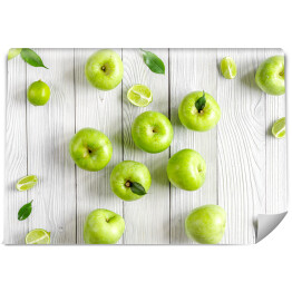Fototapeta samoprzylepna Zielone jabłka i limonki na biurku