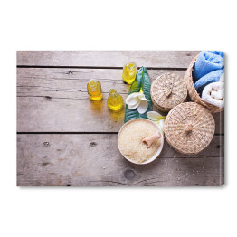 Obraz na płótnie Butelki z olejkiem aromatycznym, ręczniki, sól morska i pojemniki na akcesoria spa
