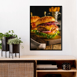 Plakat w ramie Świeży hamburger z mięsem, bekonem, serem i warzywami na drewnianej desce
