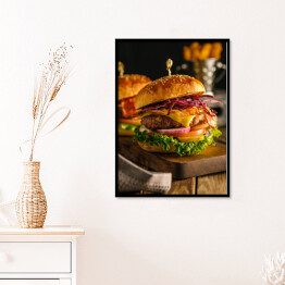 Plakat w ramie Świeży hamburger z mięsem, bekonem, serem i warzywami na drewnianej desce